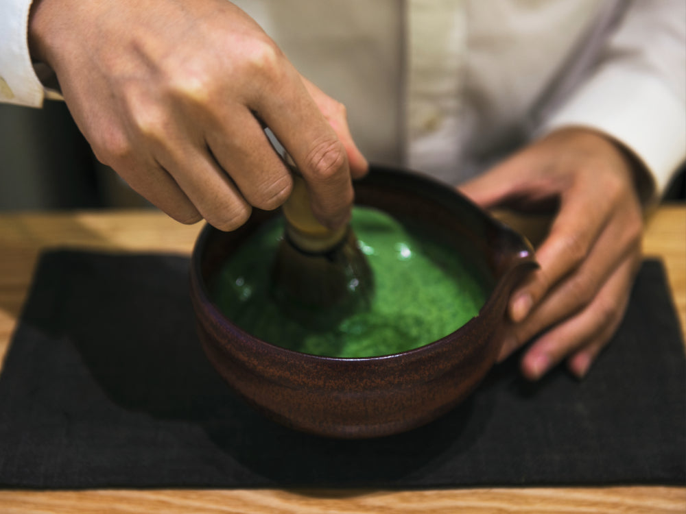 Matcha Zubereitung im Chawan mit Bambusbesen für traditionellen Matcha Tee