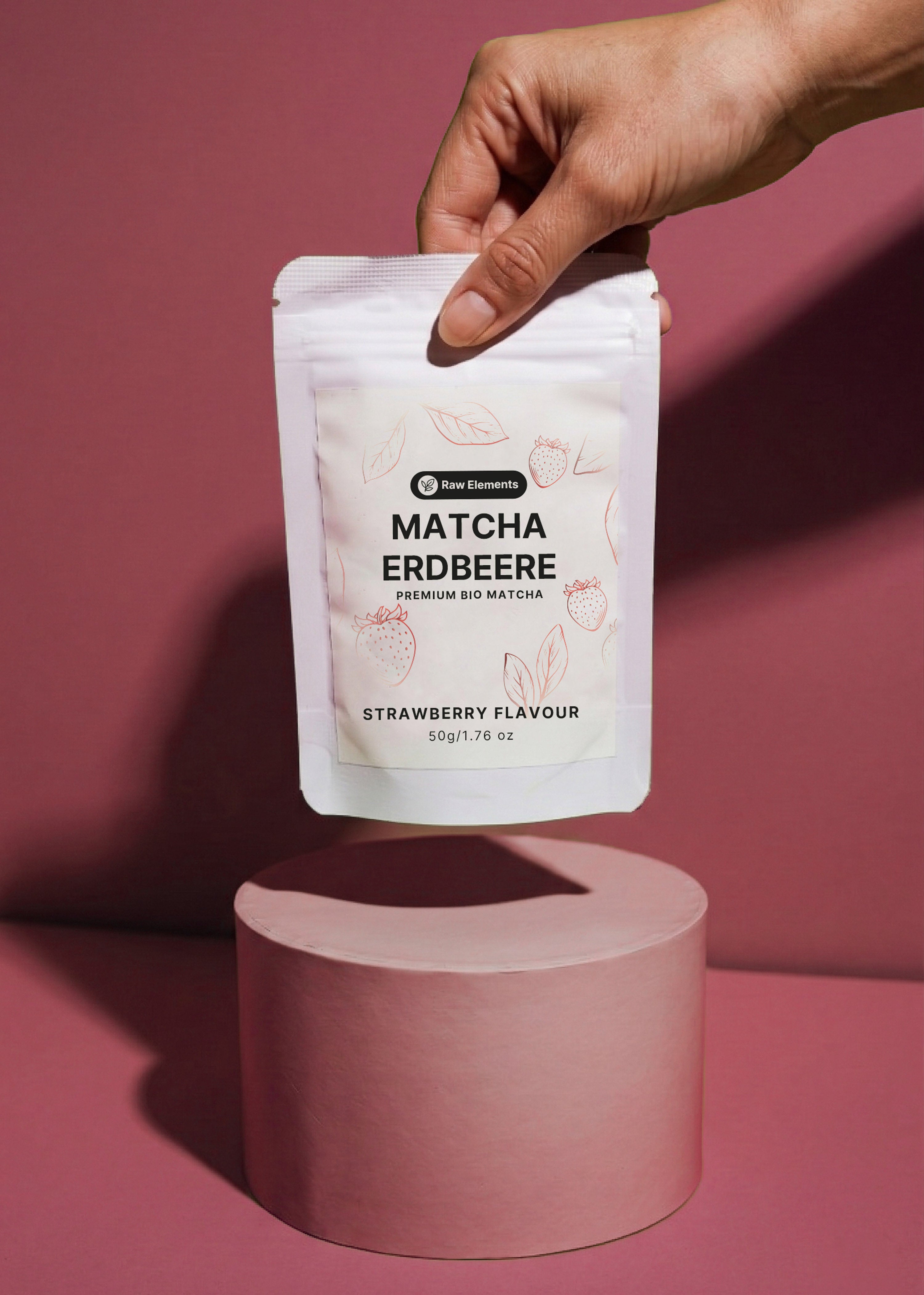 Geöffnete Packung mit leuchtend rosa-grünem Bio Erdbeer Matcha Pulver auf einer Holzoberfläche.