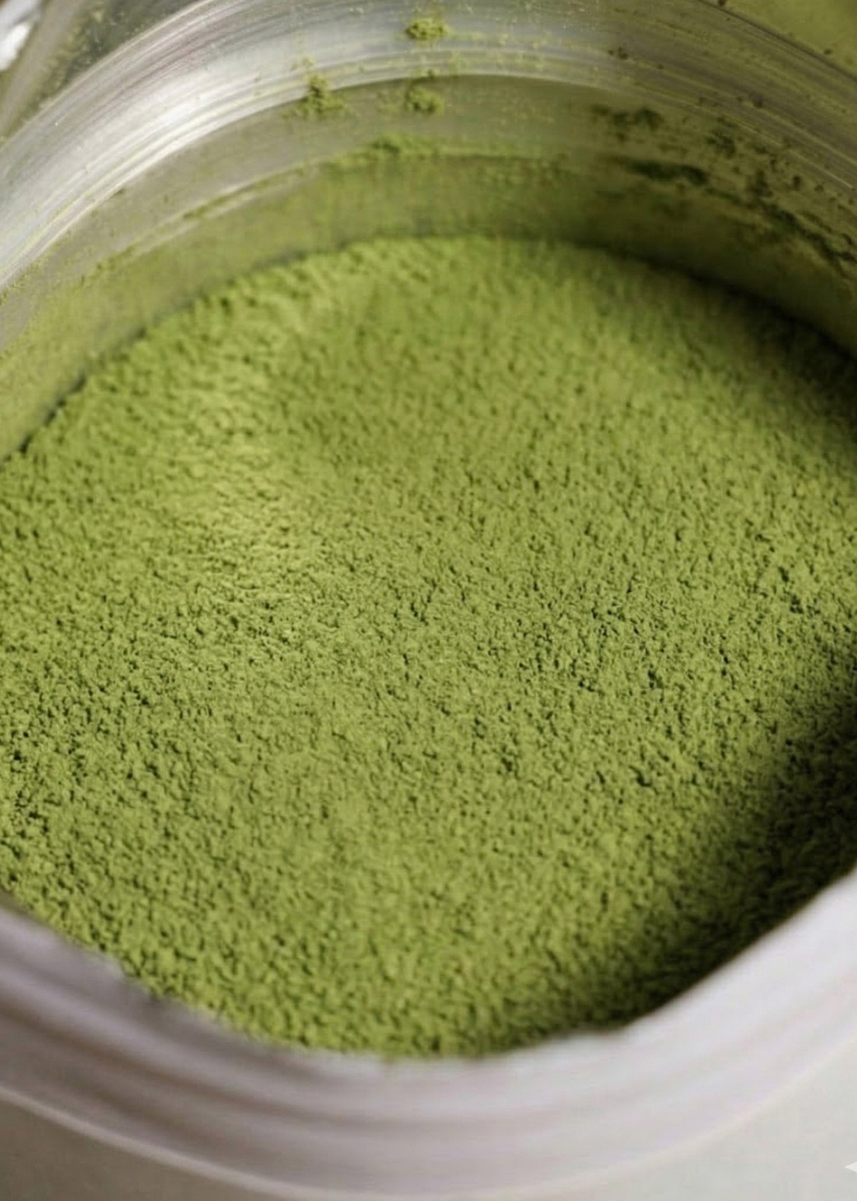 Detaillierte Nahaufnahme der feinen Textur des Bio Erdbeer Matcha Pulvers, zeigt die Mischung aus grünem Matcha und rosa Erdbeere.