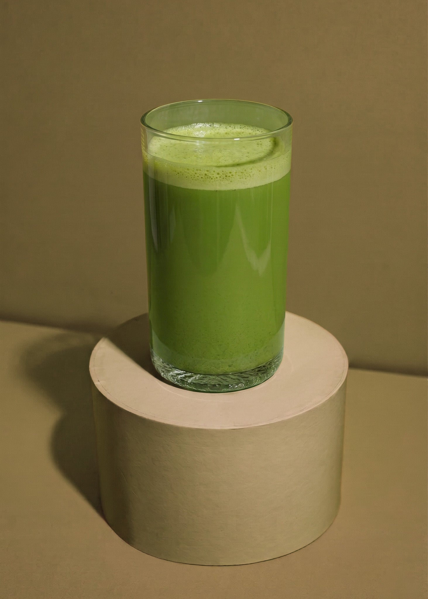 Erfrischender Iced Hojicha Latte mit Eiswürfeln und Pflanzenmilch im hohen Glas